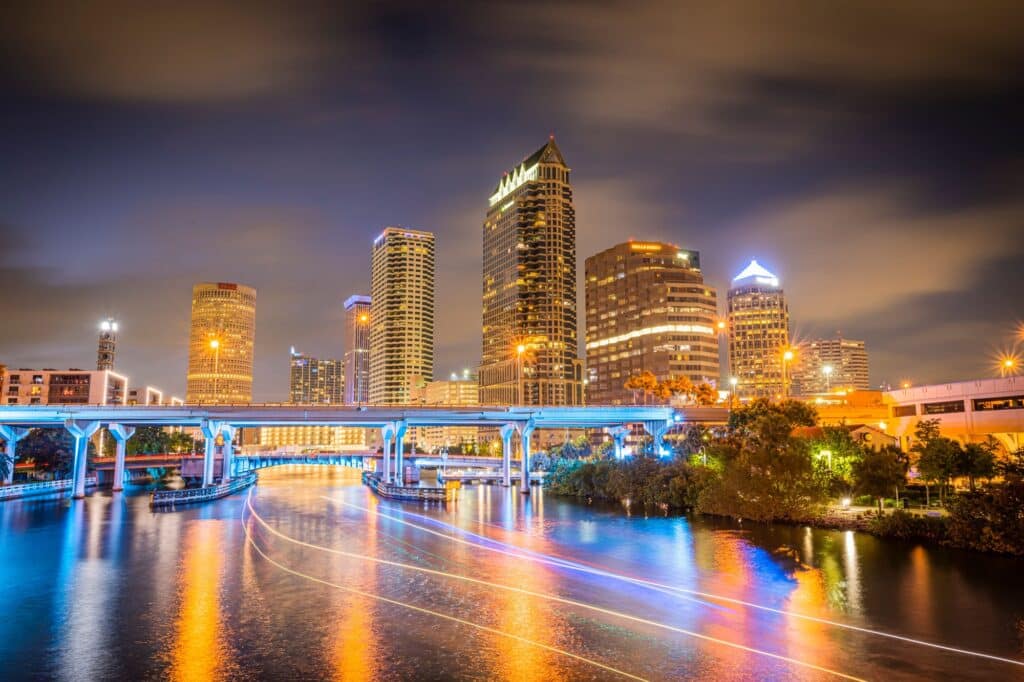 Skyline of downtown Tampa on the Hillsborough river at night under a blue sky