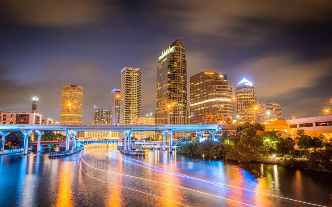 Skyline of downtown Tampa on the Hillsborough river at night under a blue sky