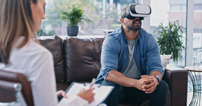 Cropped shot of a young man wearing a VR headset while sitting in session with a therapist