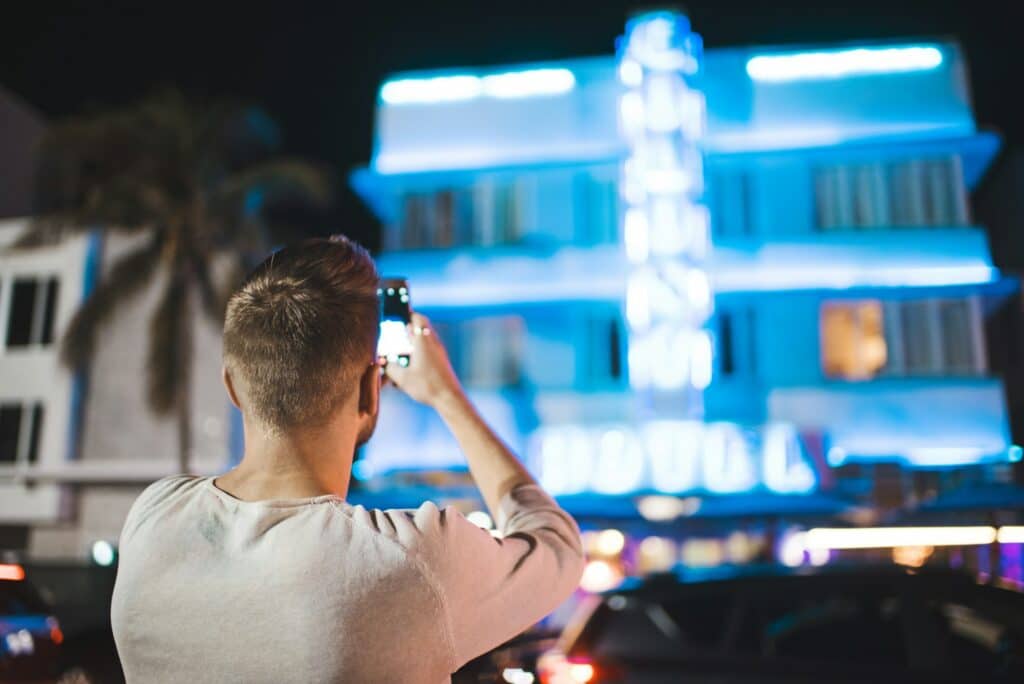 Man taking photo of hotel on cell phone in Miami